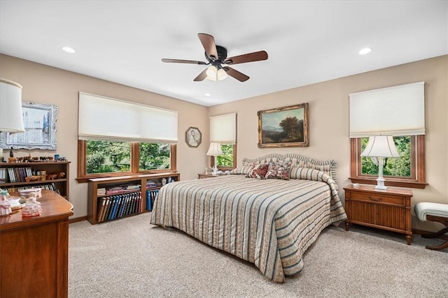 bedroom with multiple windows, light colored carpet, and ceiling fan