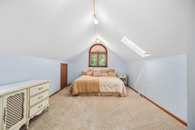 carpeted bedroom featuring lofted ceiling with skylight