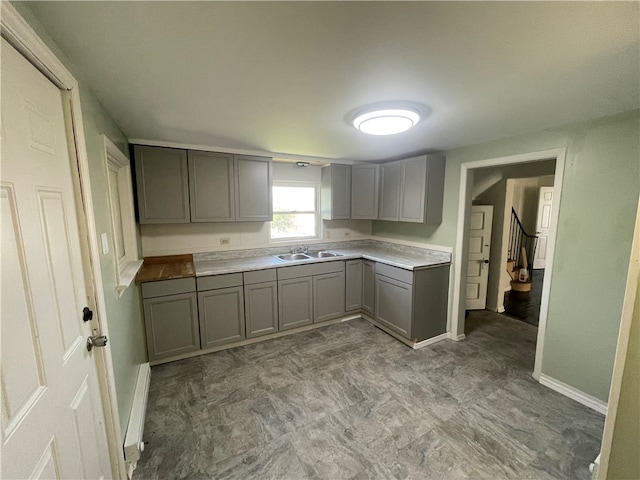 kitchen with gray cabinetry, sink, and tile floors