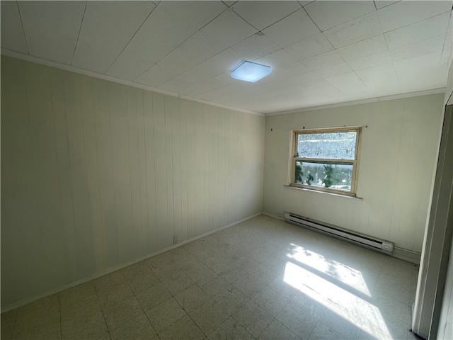 spare room with a baseboard heating unit, ornamental molding, and tile floors