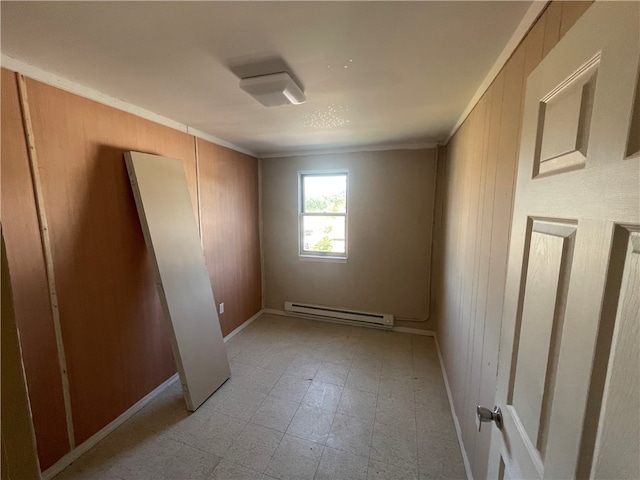 unfurnished room with crown molding, a baseboard radiator, and light tile floors