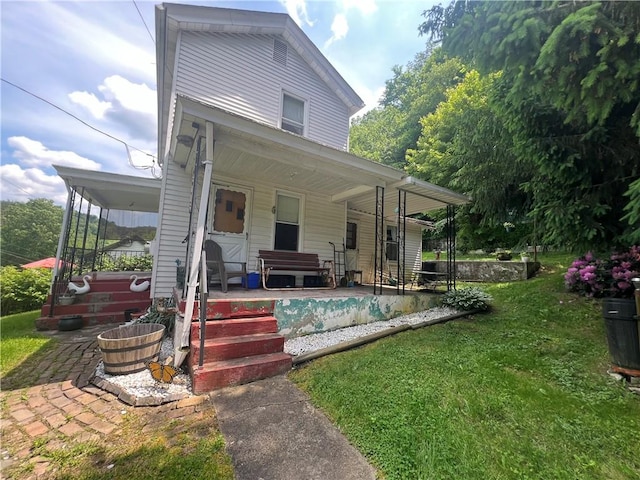 back of house featuring a porch and a lawn