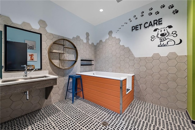 full bath featuring recessed lighting, a bath, tile patterned floors, and tile walls