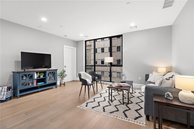 living area with baseboards, recessed lighting, wood finished floors, and visible vents