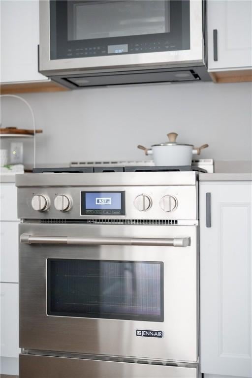 details featuring light countertops, white cabinetry, and appliances with stainless steel finishes