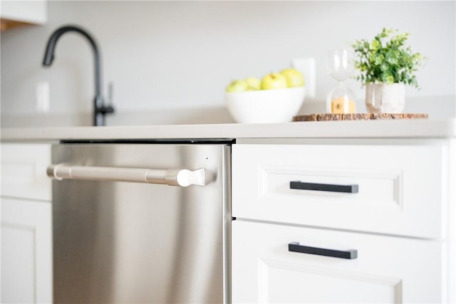 interior details featuring light countertops, dishwasher, and white cabinets