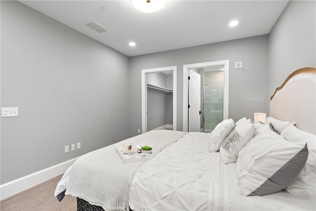 bedroom with a walk in closet, visible vents, baseboards, carpet flooring, and recessed lighting