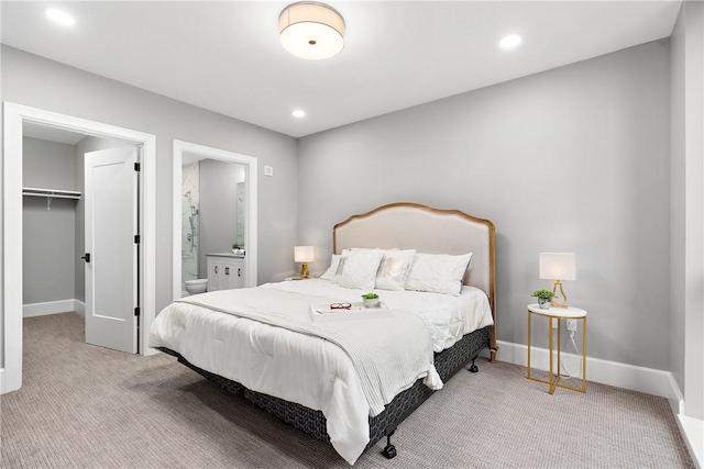carpeted bedroom featuring connected bathroom, a walk in closet, recessed lighting, baseboards, and a closet
