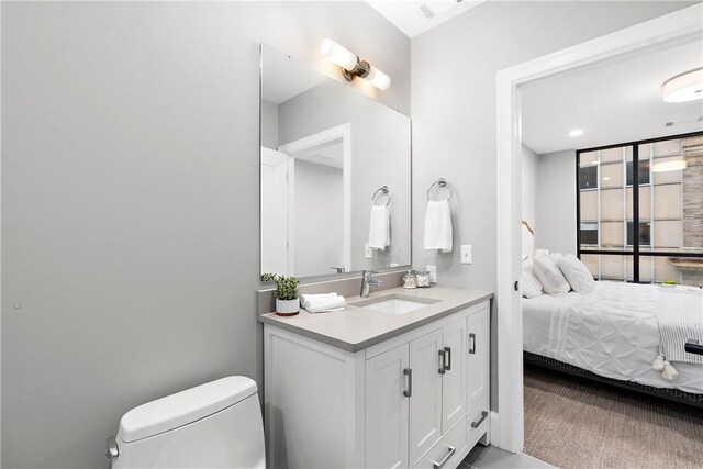 ensuite bathroom featuring vanity, ensuite bathroom, and toilet