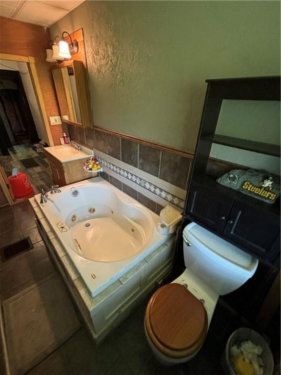 bathroom featuring toilet, a bathing tub, tile patterned flooring, and vanity