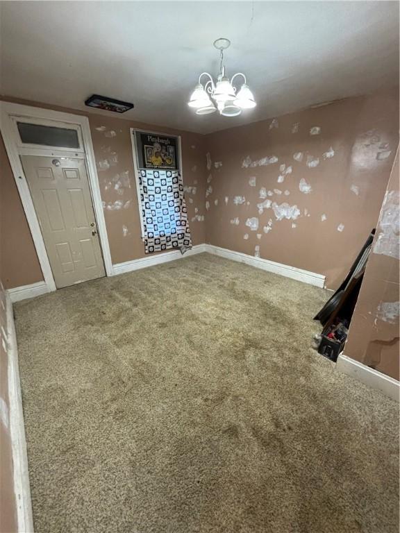 interior space featuring carpet flooring and a chandelier