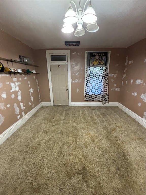 spare room with carpet flooring and a notable chandelier