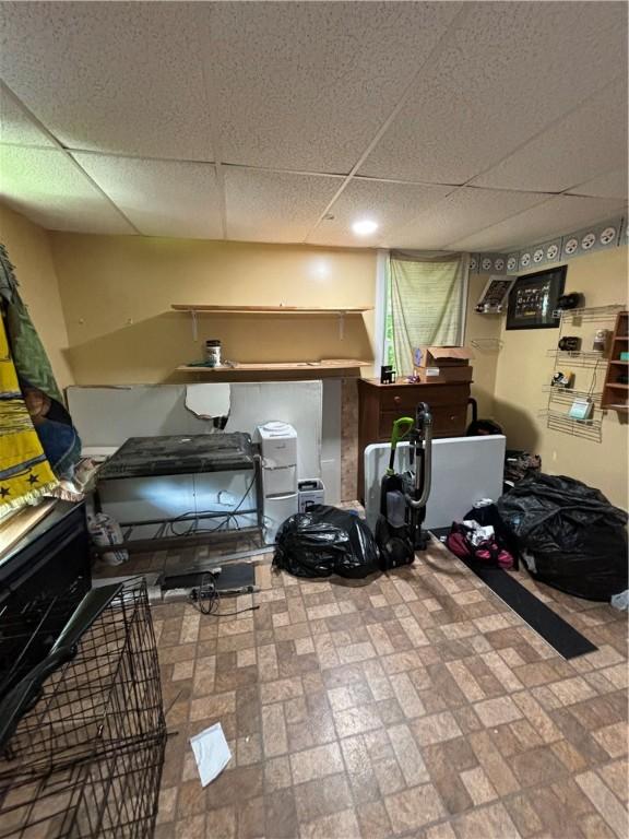 workout room with a paneled ceiling and tile patterned flooring