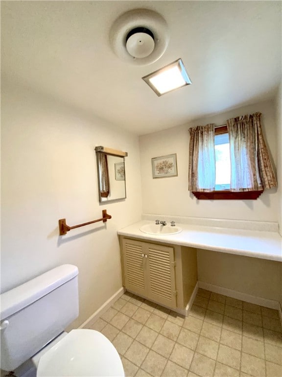 bathroom with tile flooring, vanity, and toilet