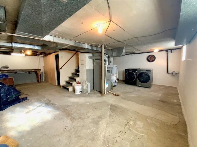 unfinished below grade area featuring washer and dryer, water heater, heating unit, and stairs