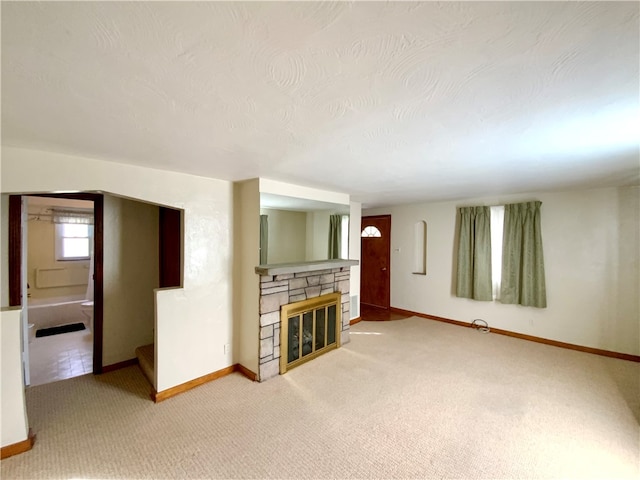 unfurnished living room featuring a textured ceiling, carpet, and a fireplace