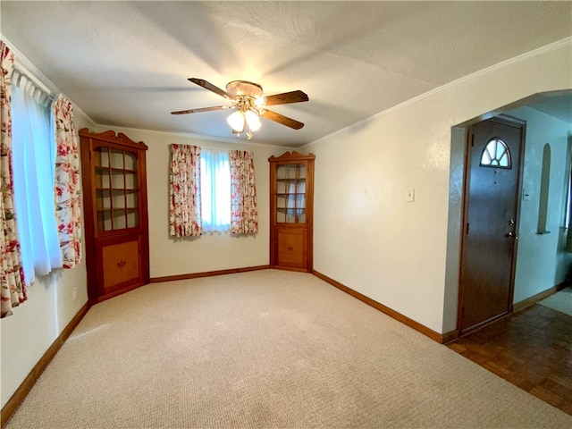 empty room with crown molding, carpet floors, and ceiling fan