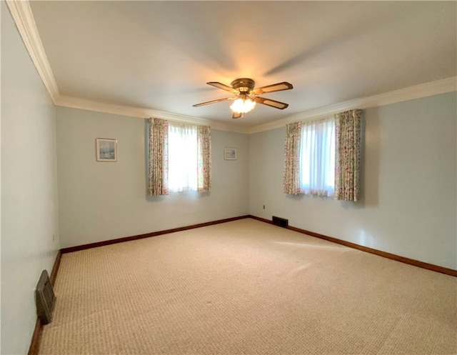 carpeted empty room with ceiling fan and crown molding