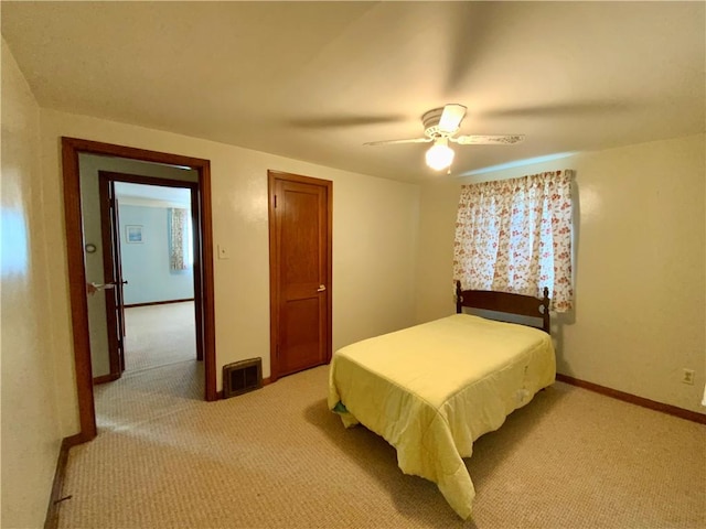 bedroom with light carpet, visible vents, baseboards, and ceiling fan