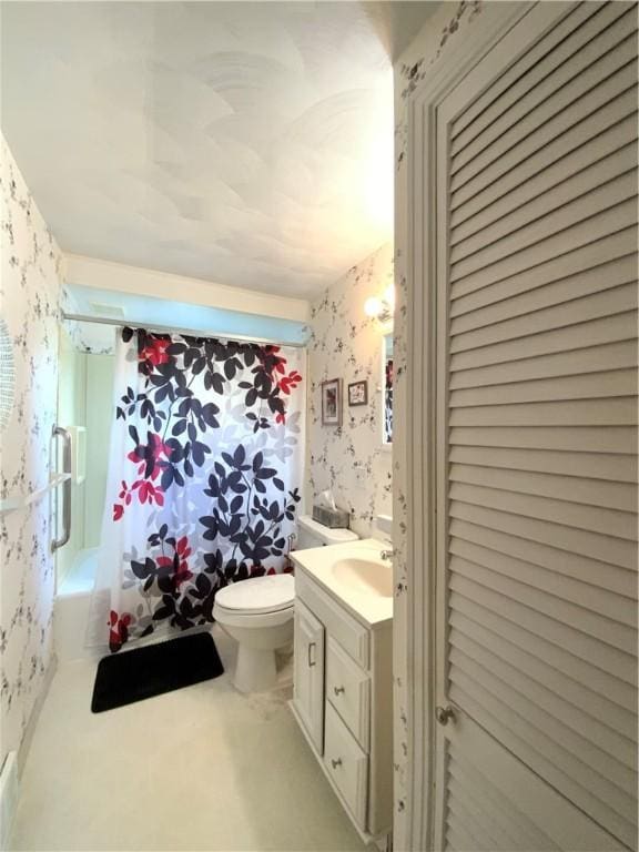 bathroom featuring toilet, wallpapered walls, a closet, and vanity