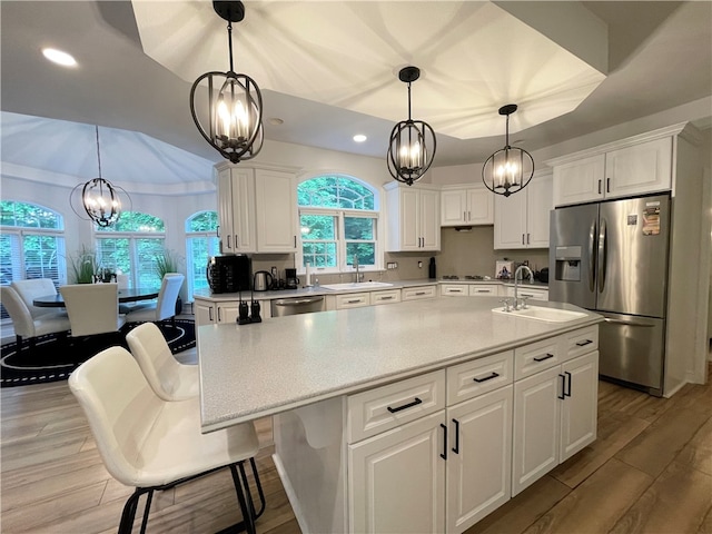 kitchen with white cabinets, appliances with stainless steel finishes, and light hardwood / wood-style flooring