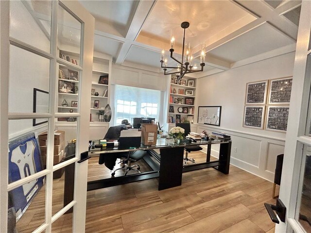 office space with a notable chandelier, beamed ceiling, hardwood / wood-style floors, and coffered ceiling