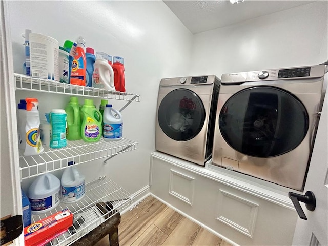 washroom with washer and dryer and light hardwood / wood-style flooring