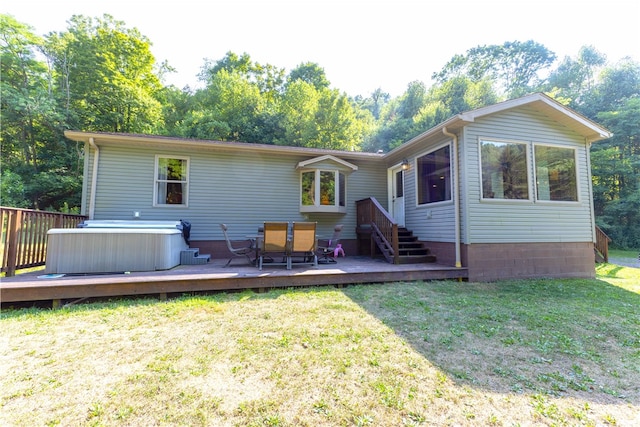 back of property with a deck, central air condition unit, and a lawn