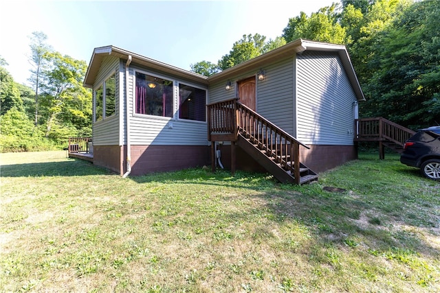 view of front of property with a deck and a front lawn