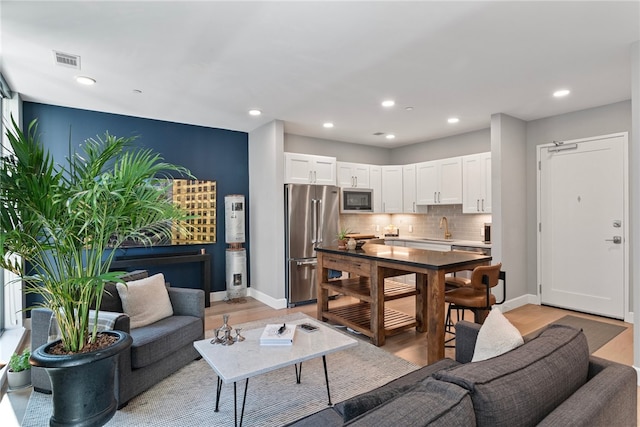 living room with sink and light hardwood / wood-style floors