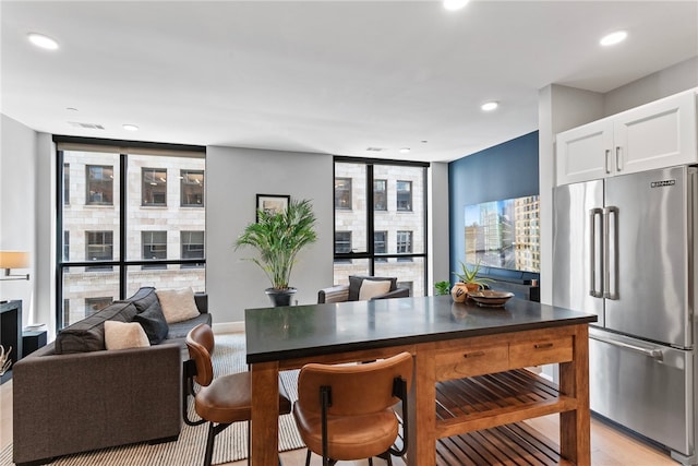 kitchen featuring white cabinetry, floor to ceiling windows, high end fridge, and light wood-type flooring