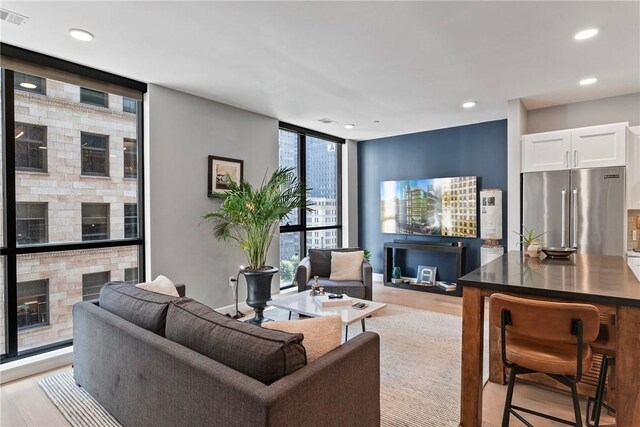 350 Oliver Ave Unit 908, Downtown Pgh, PA 15222 - living room with light wood finished floors, a fireplace, visible vents, floor to ceiling windows, and recessed lighting
