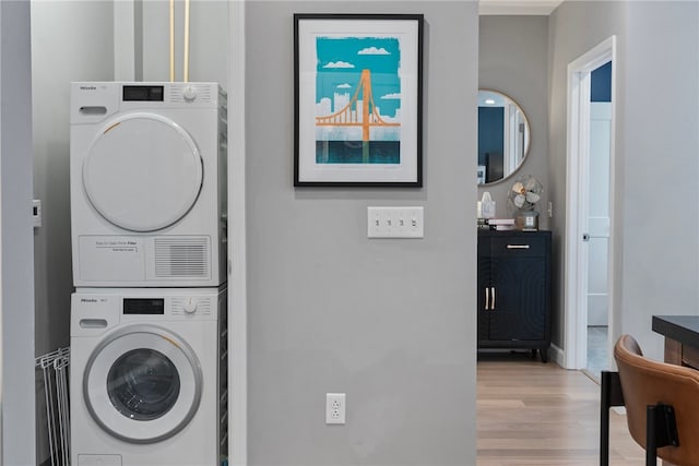 washroom with stacked washer and clothes dryer and light wood-type flooring