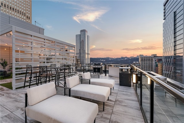 patio terrace at dusk featuring a balcony