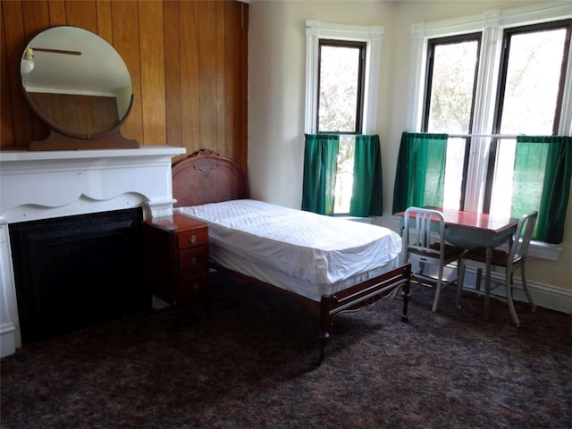 carpeted bedroom featuring wooden walls