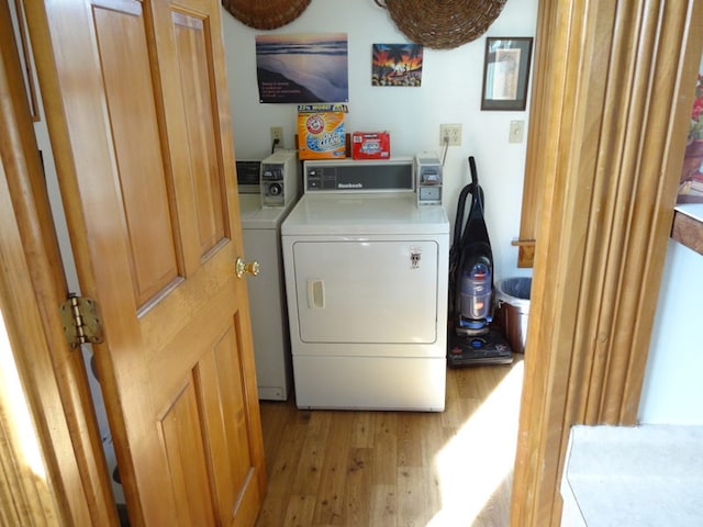 laundry room featuring washer and dryer and light hardwood / wood-style floors