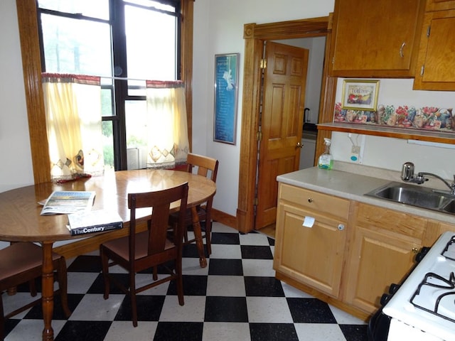 kitchen with sink, stove, and tile floors