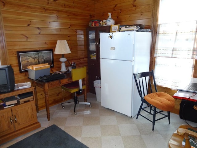 kitchen featuring wood walls, white refrigerator, and light tile floors