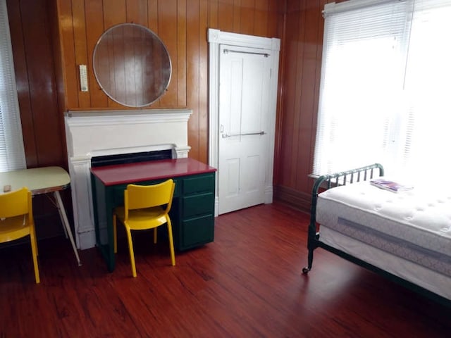 bedroom featuring dark hardwood / wood-style floors and wooden walls