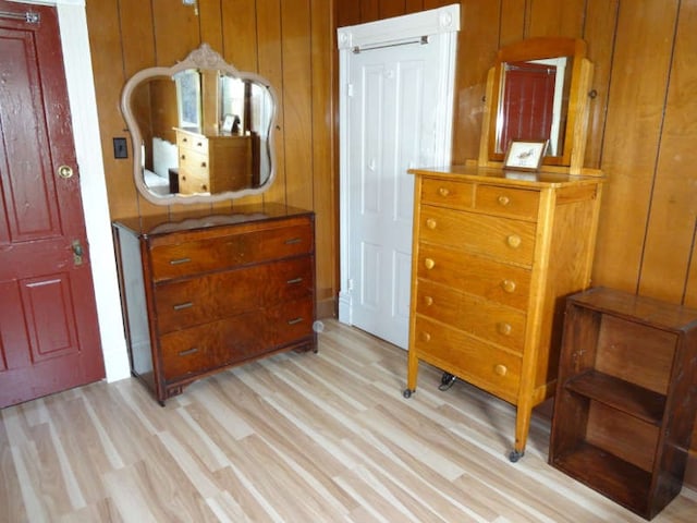 interior space with light wood-type flooring and wood walls