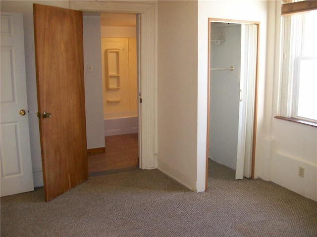 unfurnished bedroom with light carpet and a closet