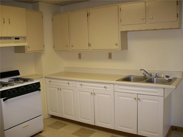 kitchen featuring white cabinetry, sink, and white gas stove