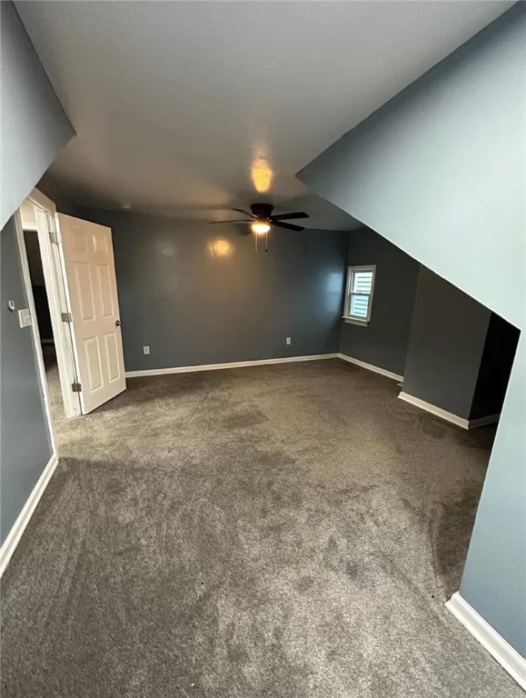 interior space with dark colored carpet and ceiling fan