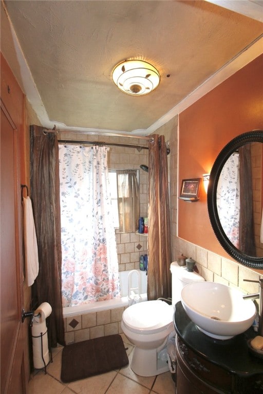 full bathroom with vanity, shower / bathtub combination with curtain, tile patterned floors, tile walls, and toilet