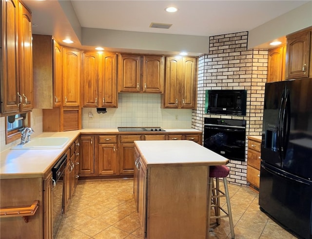 kitchen featuring a center island, black appliances, a kitchen breakfast bar, sink, and decorative backsplash