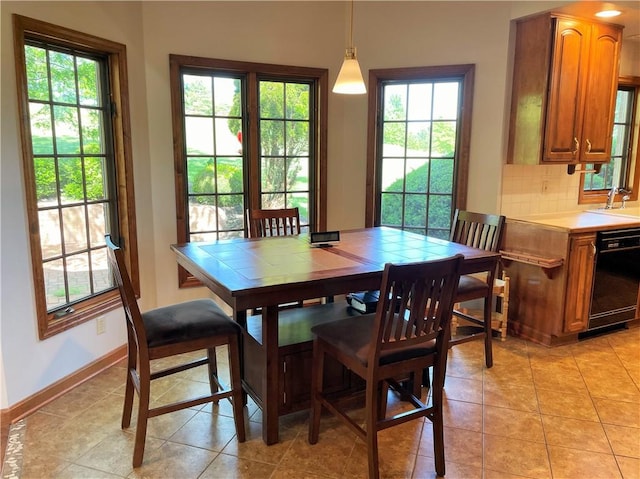 tiled dining space featuring sink and a healthy amount of sunlight