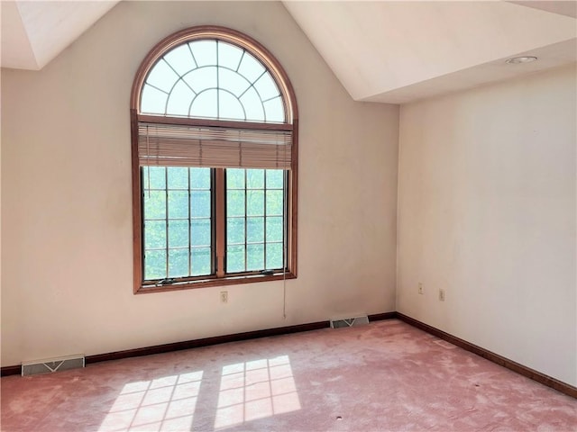 empty room with light colored carpet and lofted ceiling