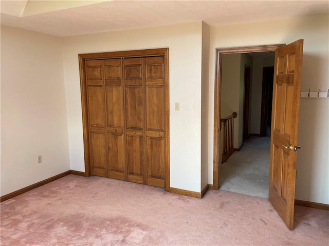 unfurnished bedroom featuring light colored carpet and a closet