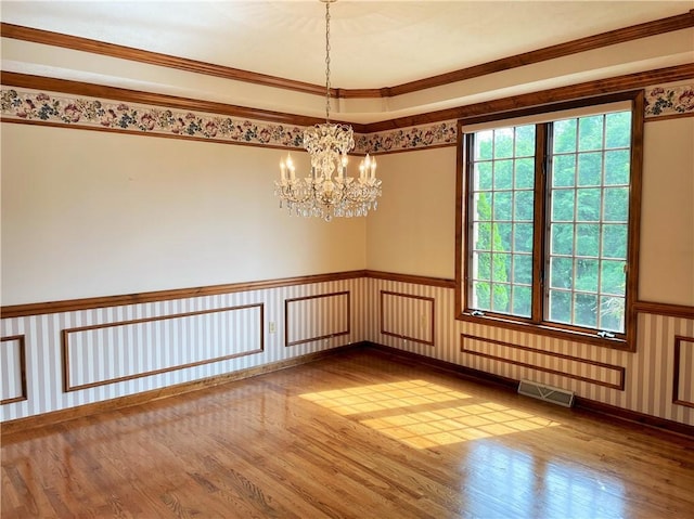 unfurnished room featuring a healthy amount of sunlight, wood-type flooring, and ornamental molding