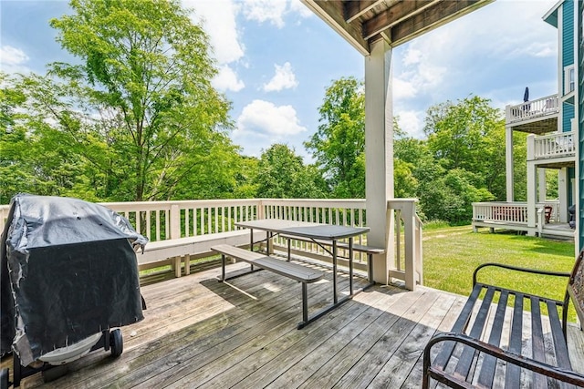 wooden terrace with a grill and a lawn